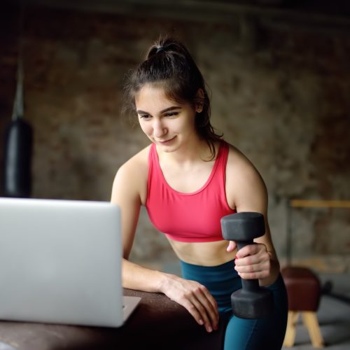 sportswoman-leads-online-fitness-class-or-herself-doing-training-using-a-laptop.jpg
